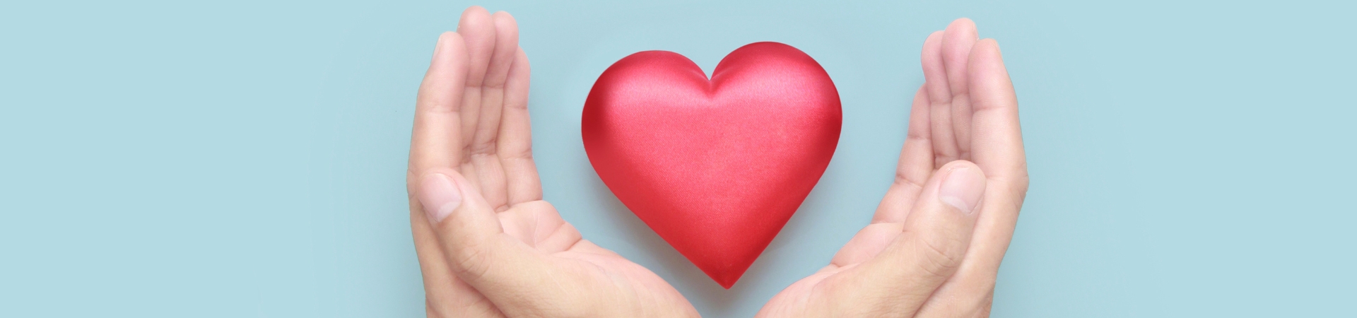 two hands holding a red heart-shaped item