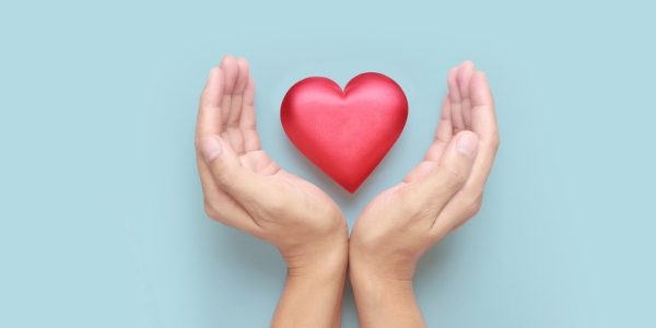 two hands holding a red heart-shaped item