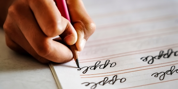 hand holding a pencil and writing