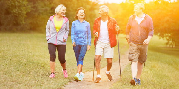 four adults walking along a path