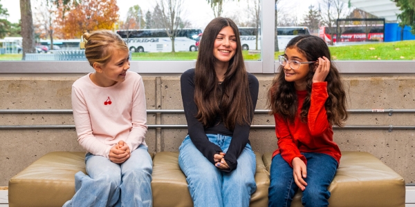 three teens seated on a bench