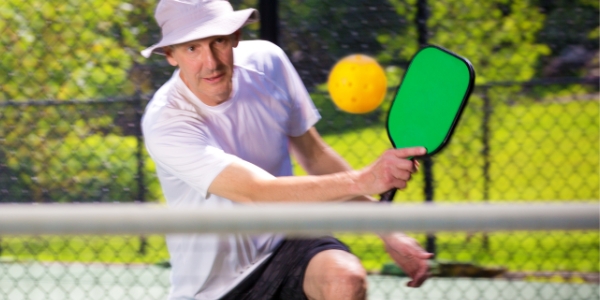 adult playing pickleball outdoors