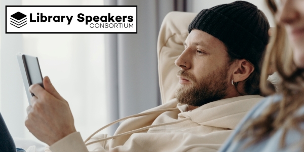 bearded adult wearing a watch cap and looking at a device beside Library Speakers Consortium logo
