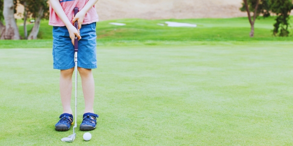child holding a golf club