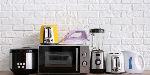various household electrical appliances lined up on a counter