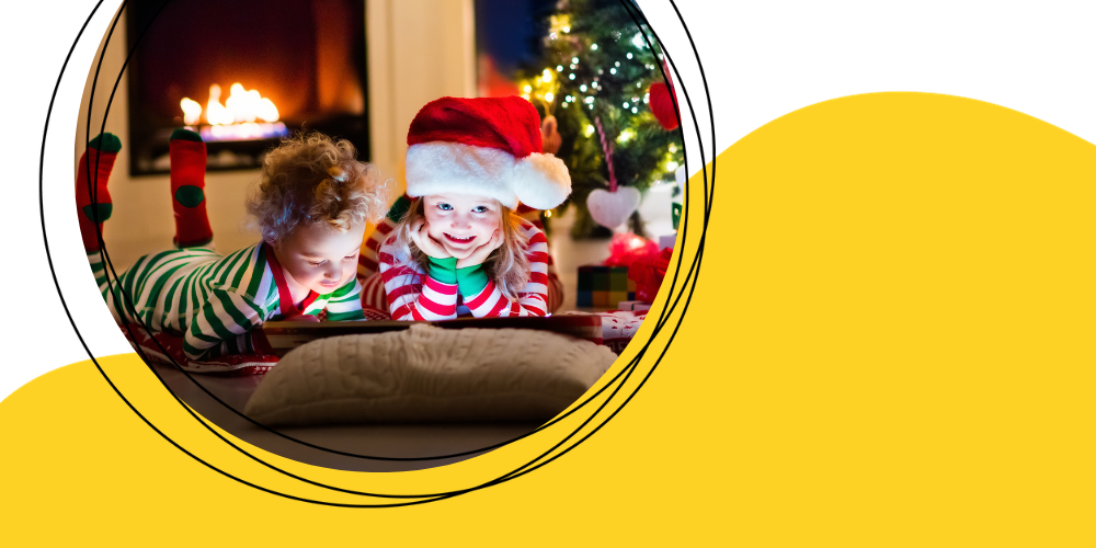  Two young children in pajamas reading a book. The girl is wearing a santa hat.