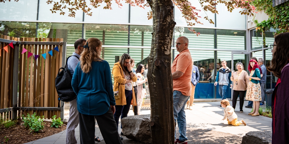 People gather around a tree in the Reading Garden
