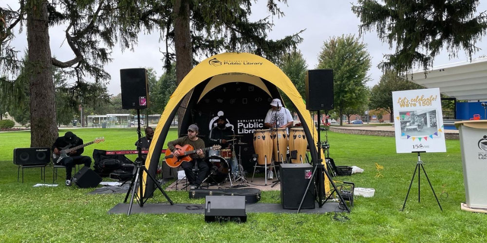 A band plays under a large yellow tent