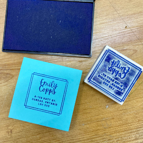 an ink pad, address stamp, and post-it with the address stamped on it