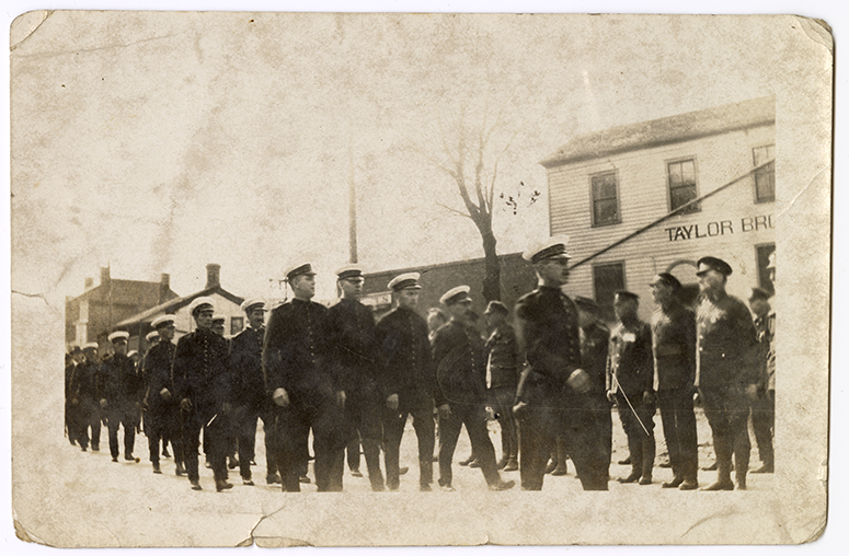 vintage photo of soldiers marching in formation on a street
