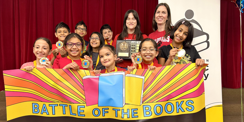group of students holding a Battle of the Books banner