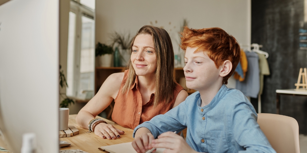 A parent and child look at a computer screen together