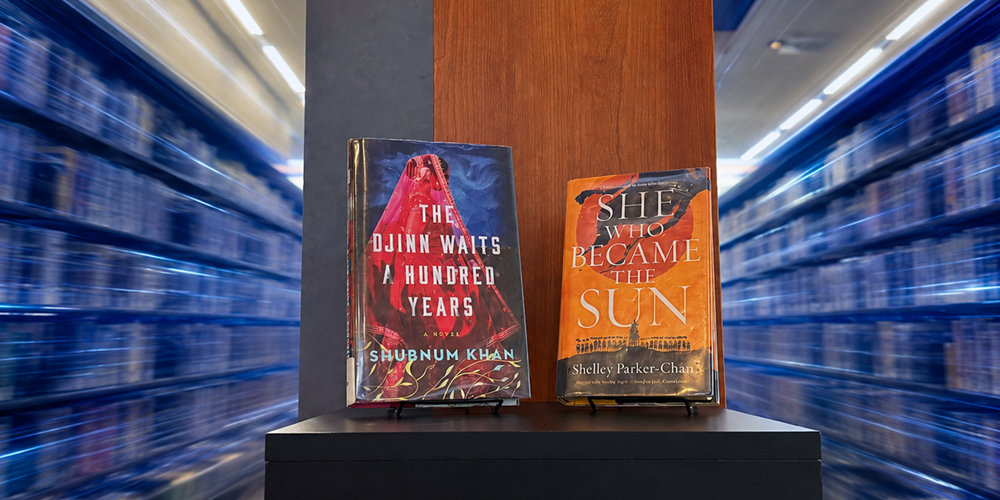 two books on display with bookshelves in background