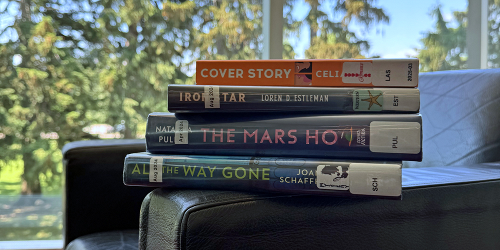 four books stacked on an armchair