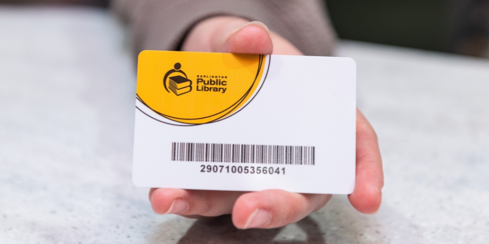 hand holding a Burlington Public Library card