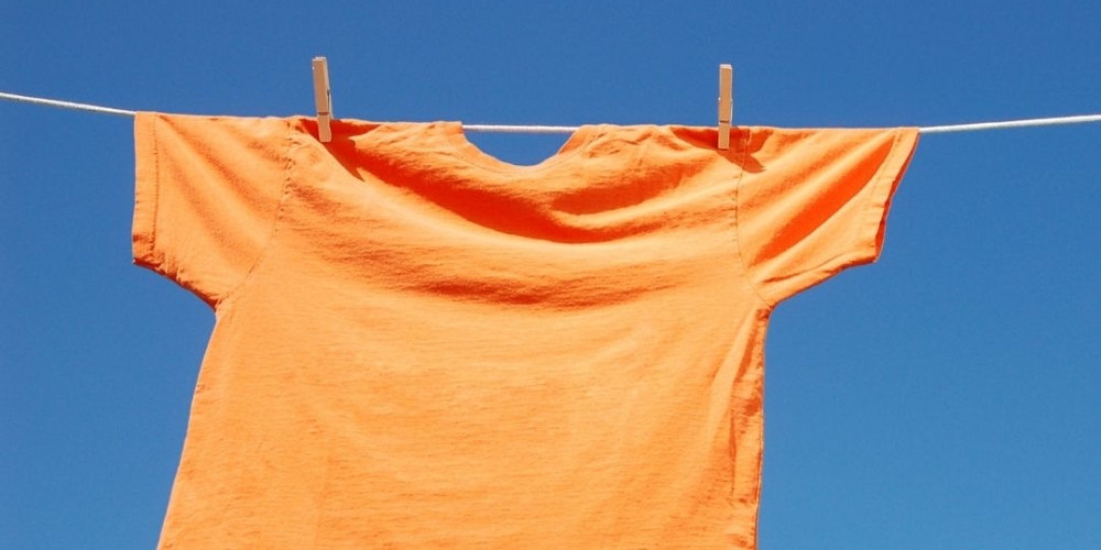 an orange shirt pegged to a clothes line