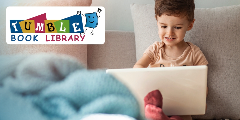 child seated on a sofa looking at a laptop