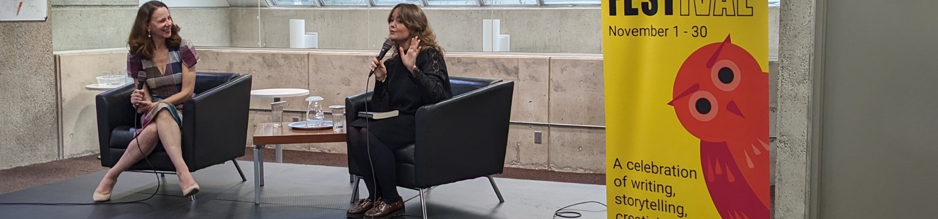 two adult seated holding microphones