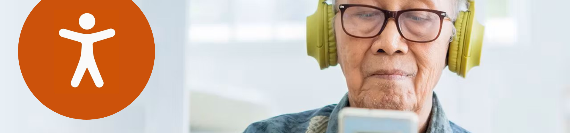 reachdeck icon of an orange circle with a white figure inside and an older person wearing headphones and looking at a device in background