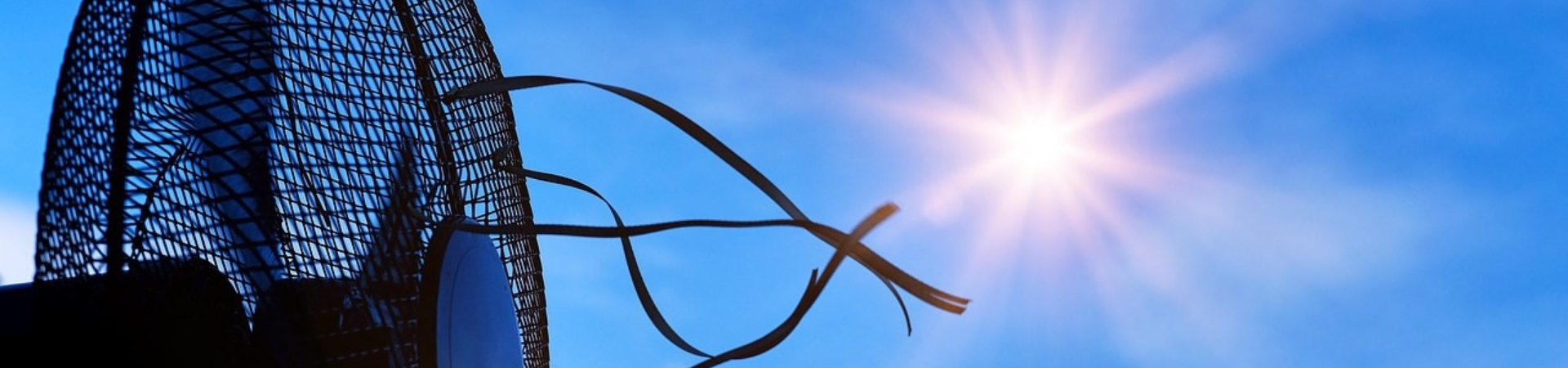 electric fan with streamers flying against a sunny blue sky background